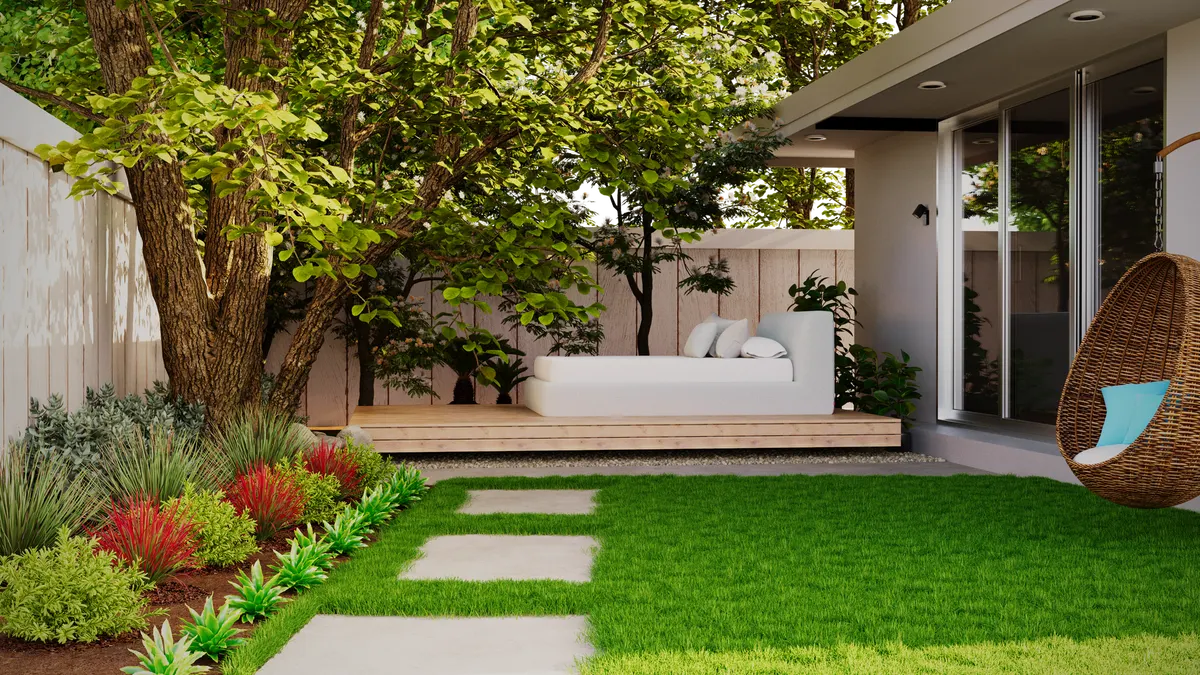 Finished modern backyard with turf, pavers, and new plantings