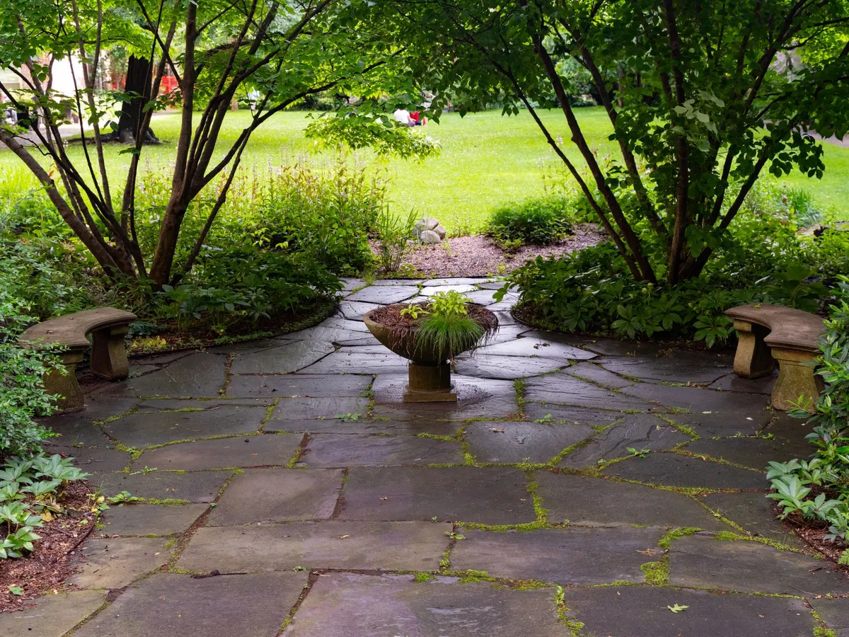 Natural stone patio set into a shaded garden