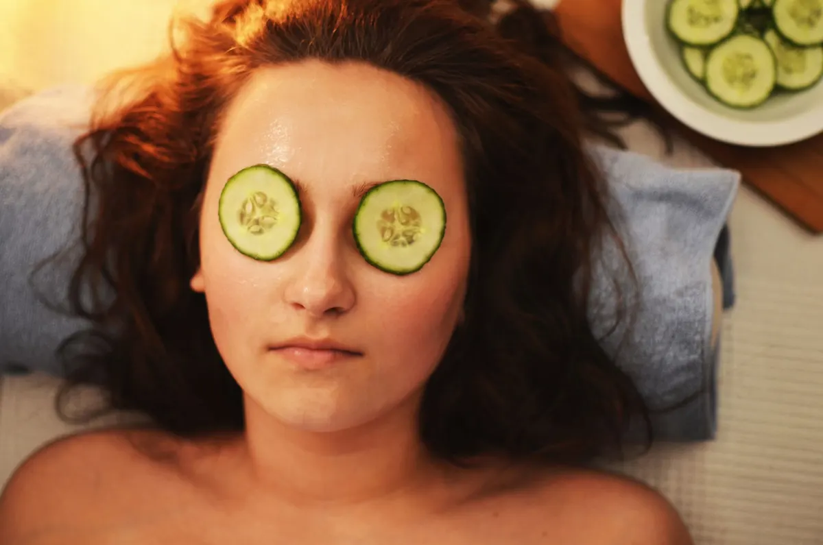Client relaxing during a spa facial with cucumber eye treatment