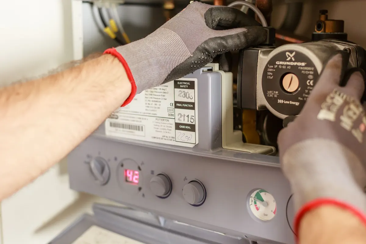 Technician adjusting a circulation pump on a residential boiler
