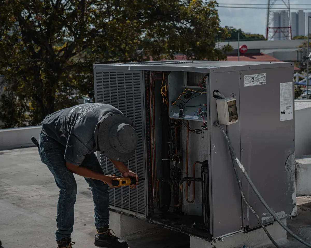 Technician servicing a commercial rooftop HVAC unit